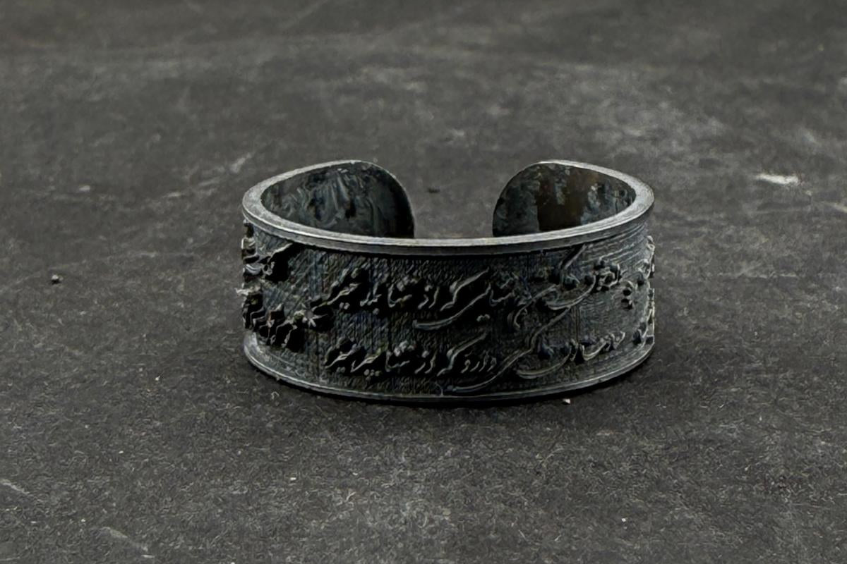 Black metal bracelet on a dark textured surface