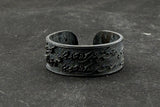 Black metal bracelet on a dark textured surface